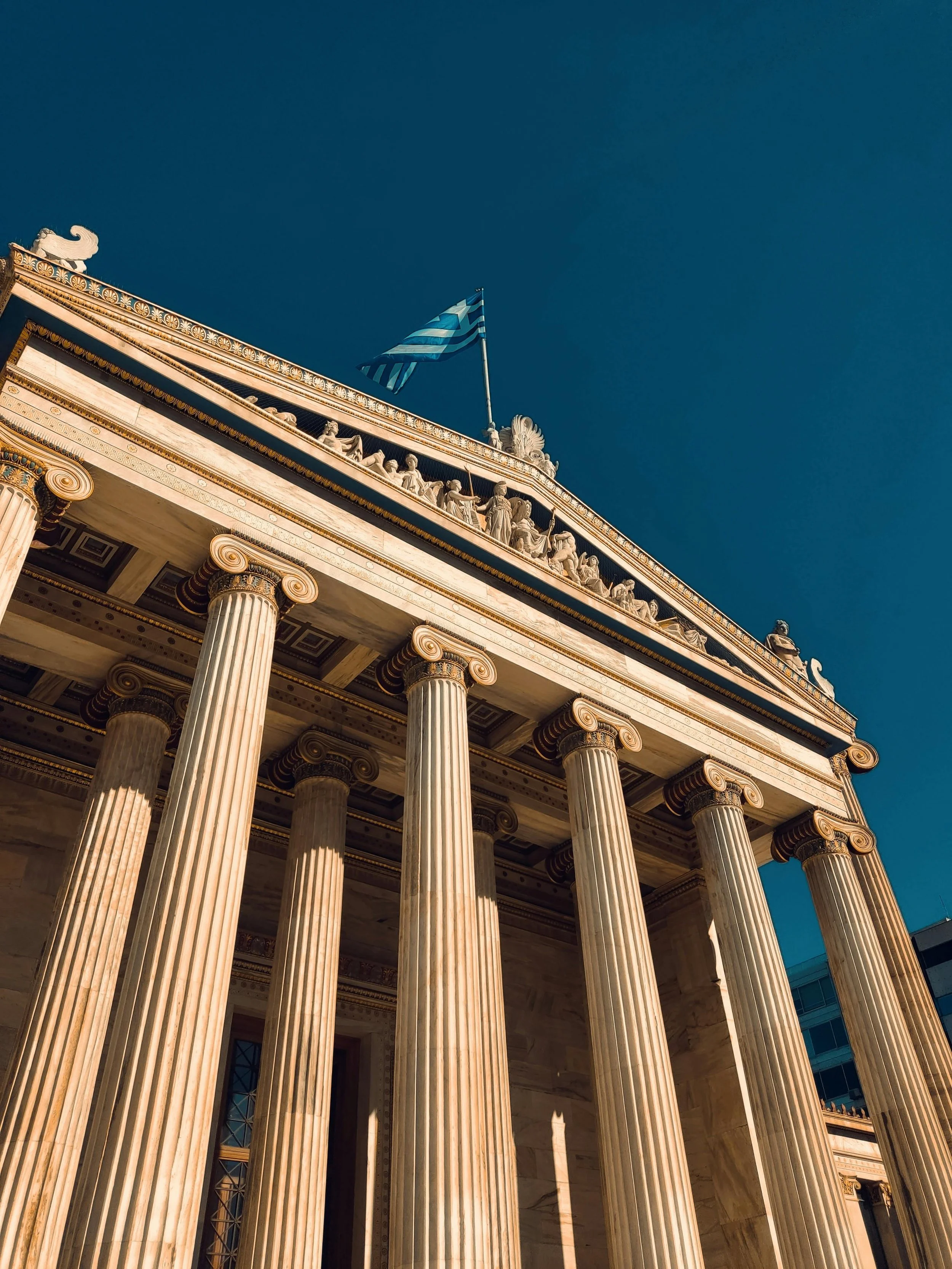 Neoclassical public building with Greek flag in Athens